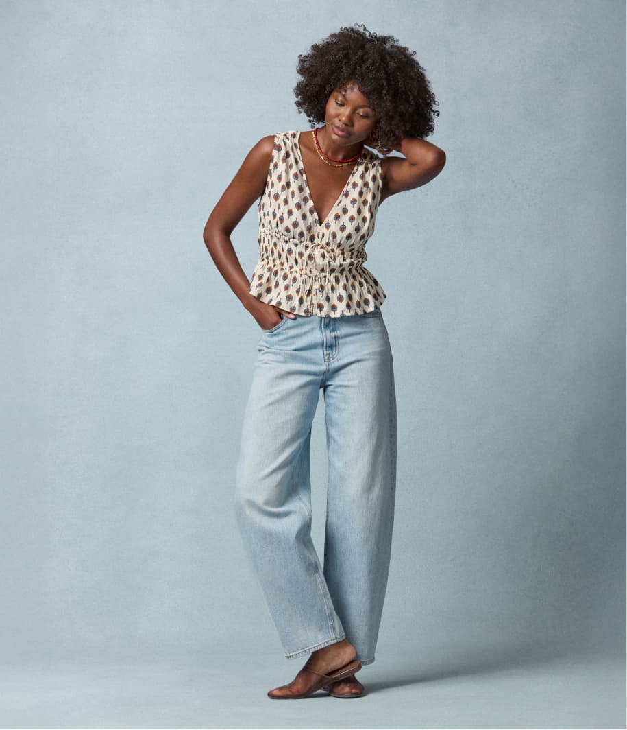 Image of woman wearing relaxed jeans with a printed tank top.