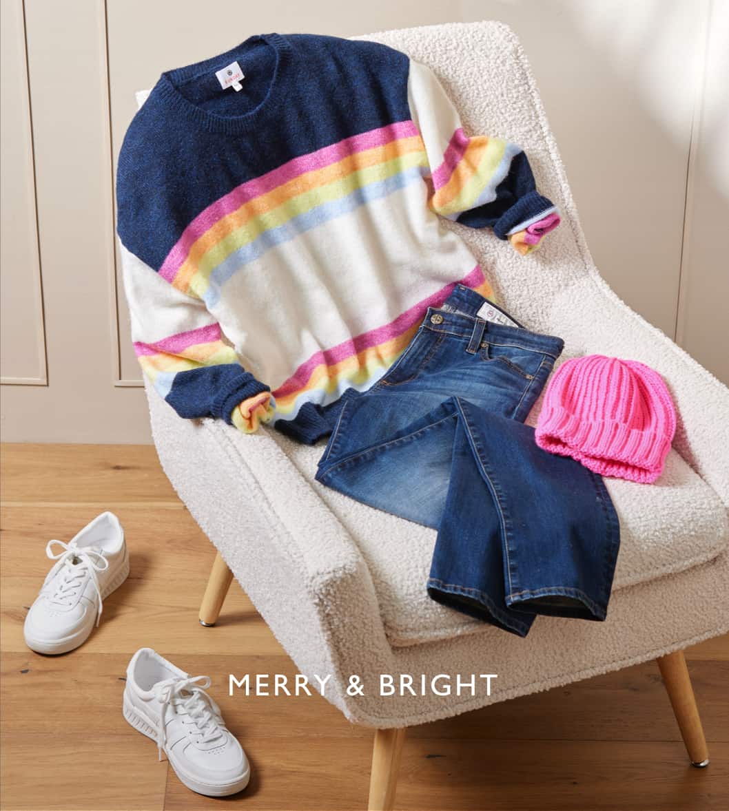 Image of outfit with a colorful striped sweater, jeans, hot pink beanie, and white sneakers laid out on a chair with the caption "Merry & Bright"