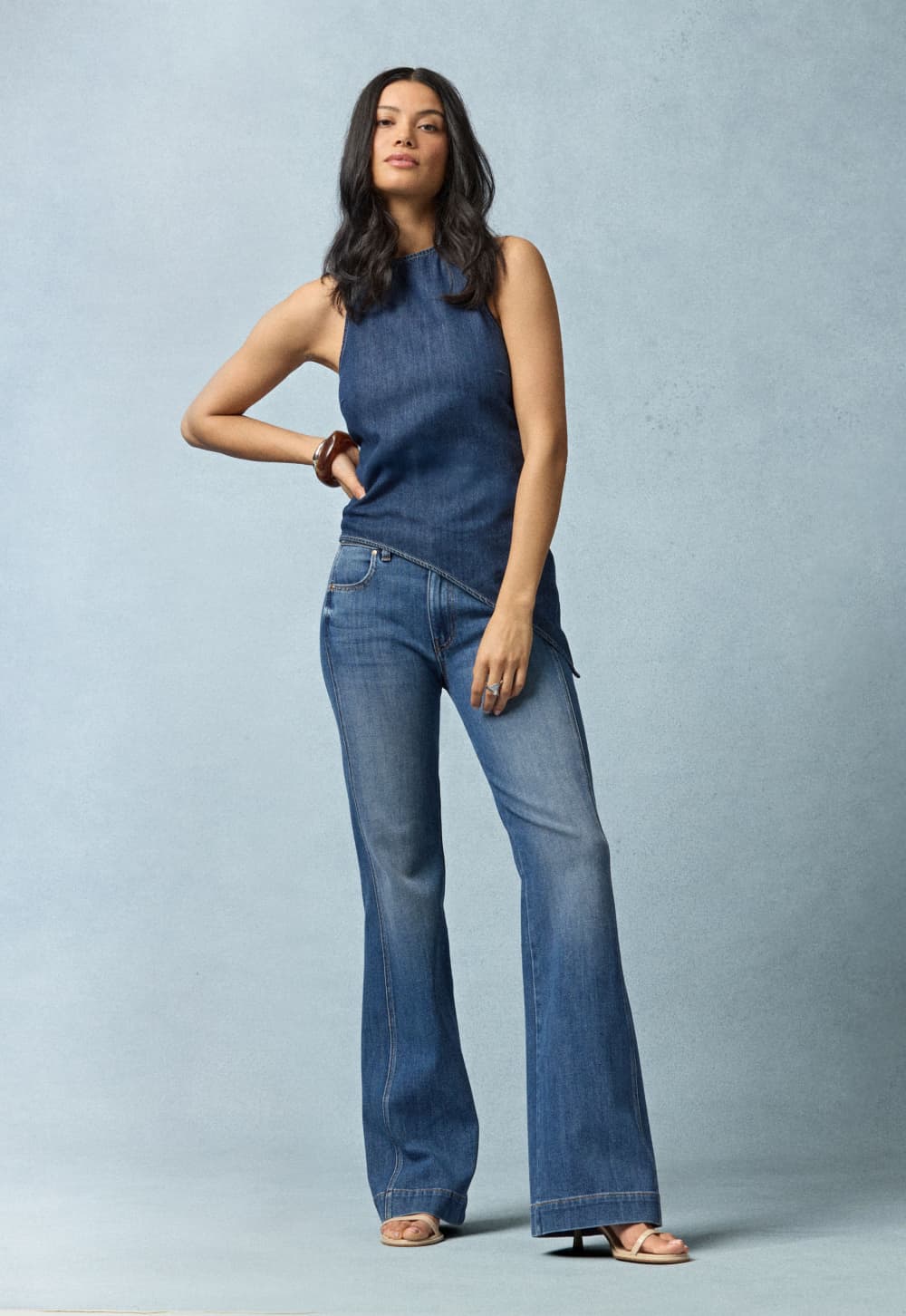 Image of woman wearing a denim tank and bootcut jeans.