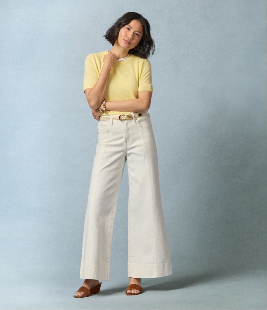 Image of woman wearing petite wide leg jeans with a yellow top.