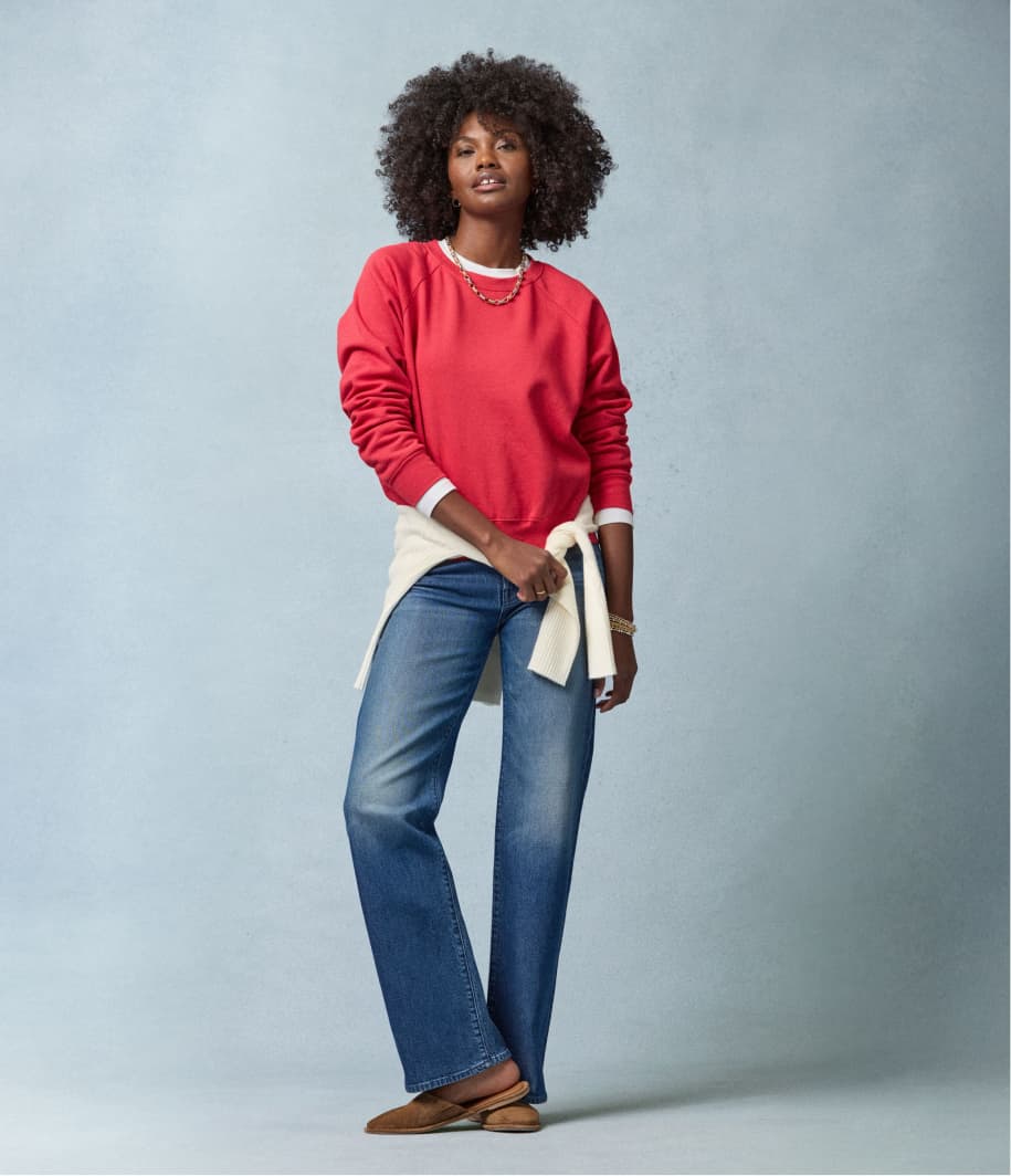 Image of woman wearing straight leg jeans with a red sweatshirt