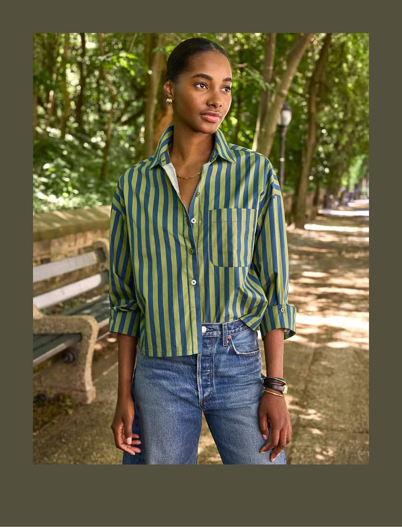 Image of woman wearing striped button down shirt and blue jeans. 