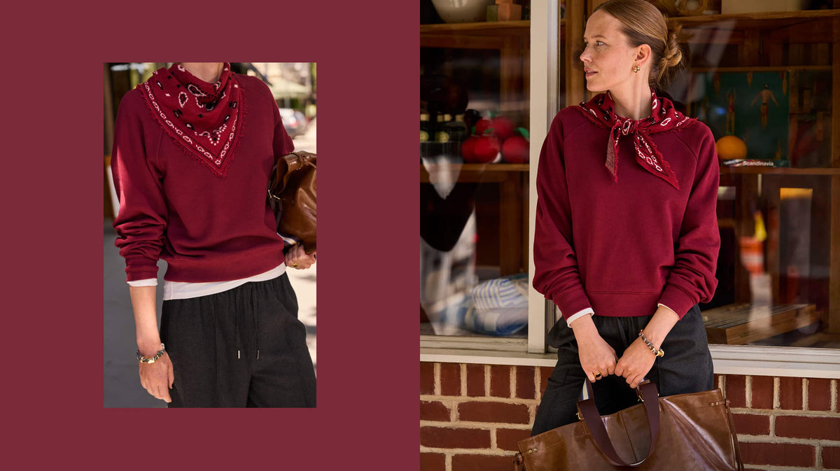 Woman wearing a maroon pullover sweatshirt with a maroon bandana scarf and black pull on pants. 