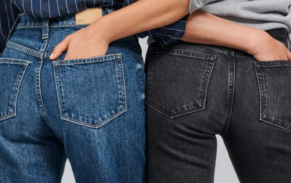 Two women wearing jeans with their hands in their back pockets